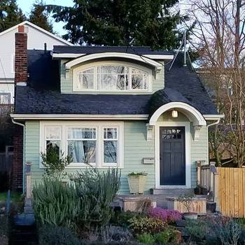 Пример красивой отделки фасада дома бирюзового цвета в кантри стиле