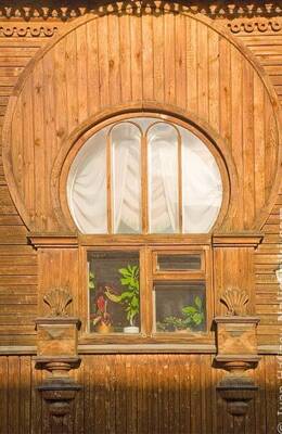 Вариант оформления фасада в деревенском стиле с интересными окнами