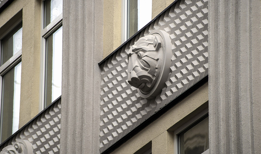 Маскарон льва на фасаде из СФБ